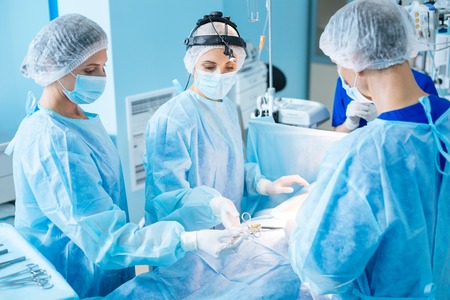Attentive medical worker taking sterile instrumentの写真素材
