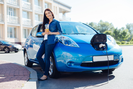 Delighted beautiful woman holding orange juiceの写真素材