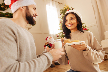 Smiling couple treating themselves to oatmeal cookiesの写真素材