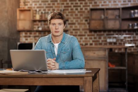 Handsome man sitting at the workplace with laptopの写真素材
