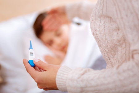 Colorful thermometer in the hands of a young woman