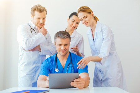 Friendly medical professional looking at laptop and smilingの写真素材