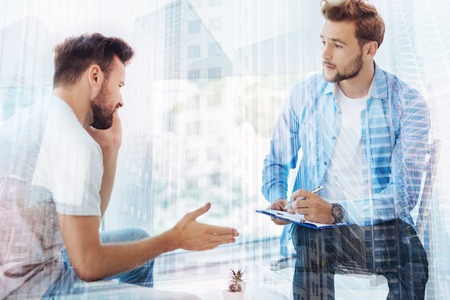 Young doctor talking with his patientの写真素材