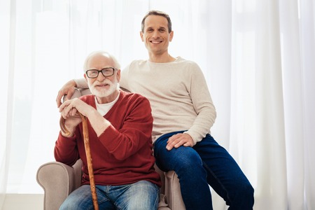 Positive delighted male relatives posing on camera