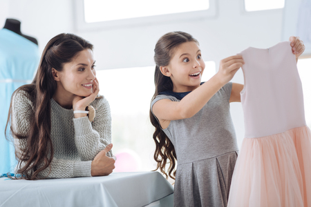 Cheerful beautiful woman watching her daughterの写真素材