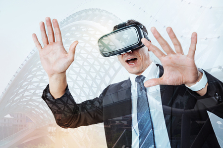 Pleasant excited man testing new technologiesの写真素材