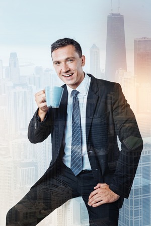 Positive handsome businessman having a break from workの写真素材