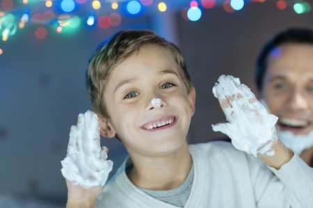 Positive delighted boy raising his handsの写真素材