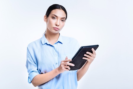 Beautiful woman in blue shirt holding a tablet