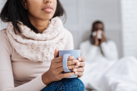 Calm relaxed woman sitting with a cup of hot drinkの写真素材