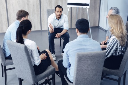 International office worker sitting in front of his partners