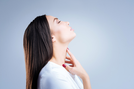 Pleasant memories. Kind romantic beautiful woman standing with her eyes closed and leaning her head back while remembering pleasant days being spent with her beloved manの写真素材