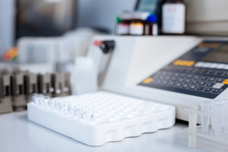 More samples. Empty little glass test tubes desire for being used while surrounded by medical appliances and situated on the white surfaceの写真素材