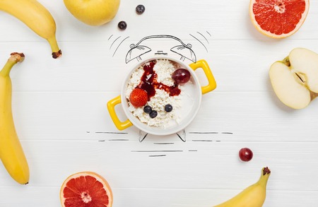 Wake up call. Top view of outmeal standing on the table with fresh fruits lying nearbyの写真素材