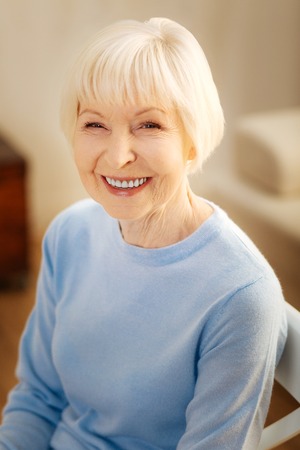 Express positivity. Amazing elderly woman feeling happiness while looking at camera, showing her...