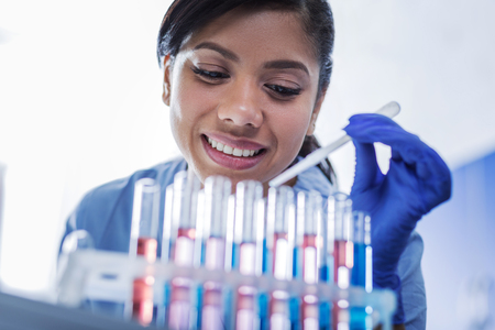 Female scientist. Portrait of a happy positive woman smiling and being in a good mood while working...