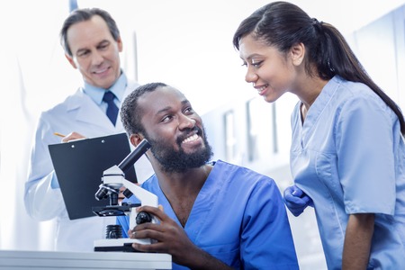 Team of professionals. Joyful nice smart doctors being in the lab and working together while being a teamの写真素材