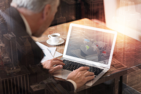 Innovative strategies development. Selective focus on a laptop used by a successful man wearing suit sitting at a table and working on a new business plan.の写真素材