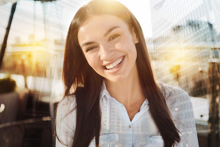Great joke. Confident enthusiastic woman looking at the camera and posing on the blurred background and smilingの写真素材