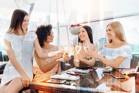 At the restaurant. Delighted nice attractive women sitting at the table and drinking champagne while having a hen partyの写真素材