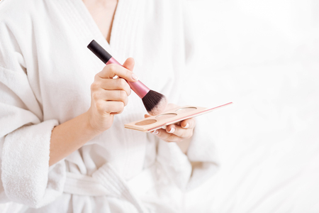 Beige powder.  Beautiful tender woman  hands holding tassel and preparing for making maquillage by using powderの写真素材