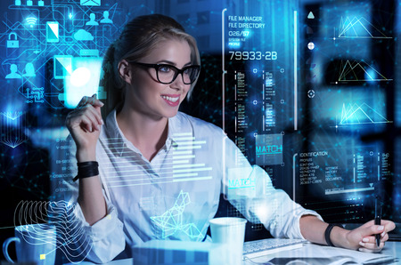 Emotional woman. Smart enthusiastic smiling programmer feeling good while looking at the screen of a...
