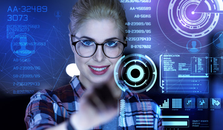 One touch. Clever qualified responsible programmer feeling confident while touching the transparent screen and smilingの写真素材