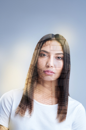 Move on. Brunette young ambitious woman looking at the camera while thinking and creating new ideasの写真素材