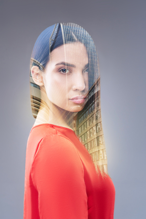 City view.  Creative thoughtful nice woman posing on the isolated background and putting hands on the head while staring at the cameraの写真素材