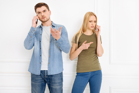 Just listen. Serious blonde female wrinkling forehead and raising hand while talking per telephoneの写真素材