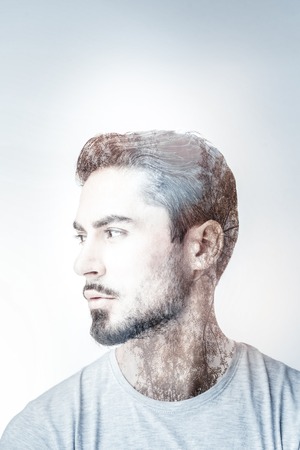 Taking decision. Handsome male person turning head and wrinkling forehead while looking forwardの写真素材