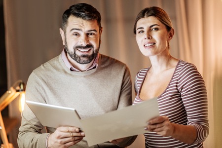 Working process. Delighted young people expressing positivity and standing together while looking straight at cameraの写真素材