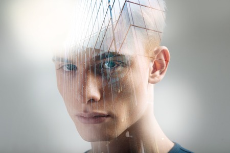 Imagination is boundless. Handsome thoughtful redhead spending time alone in the bright room man looking straight focusing his view.の写真素材