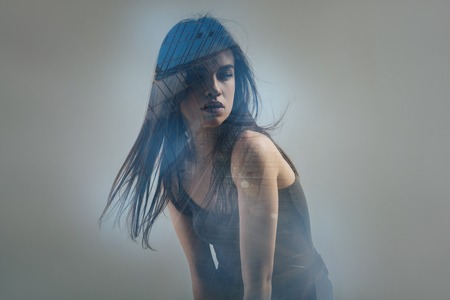 Who is there. Deep concentrated pretty woman sitting in the empty room thinking and looking aside.の写真素材