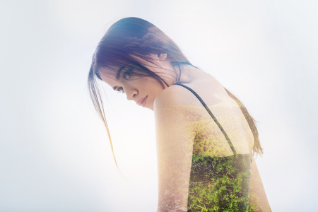 Calmness. Pretty serious young woman standing round shouldered and feeling calm while looking into the distanceの写真素材