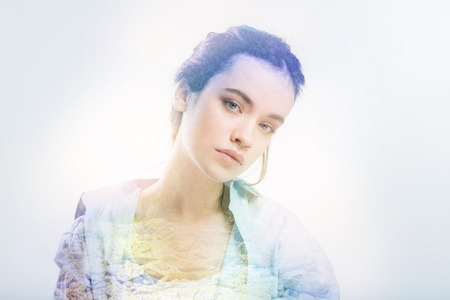 Calm student. Beautiful thoughtful student feeling calm and leaning her head while looking at the information on the blackboardの写真素材