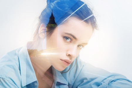 Strict teacher. Calm clever experienced strict teacher sitting at the table and thoughtfully looking at her smart pupilsの写真素材