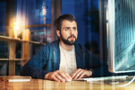 Important information. Calm attentive responsible employee sitting in his comfortable office alone...