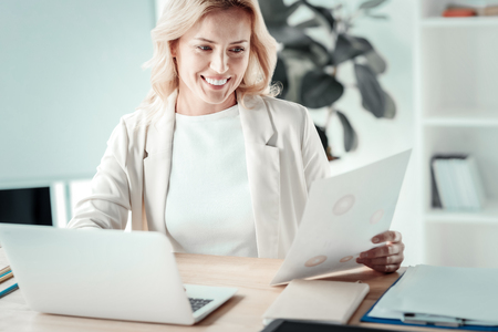 Like it. Cheerful female person smiling while working, being high spiritedの写真素材