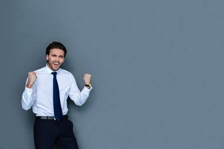 Successful deal. Joyful positive emotional businessman being at work and expressing his emotions while being happy about a successful dealの写真素材