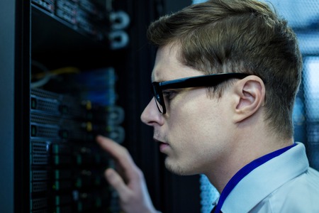 Serious young operator looking at the equipment and thinkingの写真素材