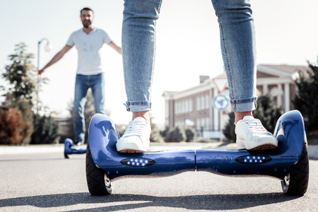 Its comfortable. Satisfied young interested people riding and tasting self-balancing scooters...