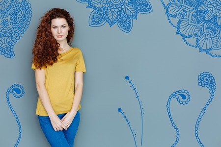 Calm model. Professional model looking calm while standing against the grey background and posing for a photoの写真素材