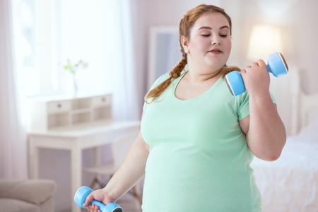 Home workouts. Proud young woman doing first steps in improving her healthの写真素材