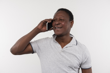 Pleasant communication. Joyful nice man putting his phone to the ear while talking on the phoneの写真素材