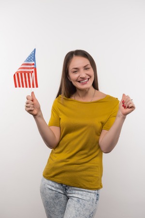 American patriot. Positive young woman smiling while supporting her countryの写真素材