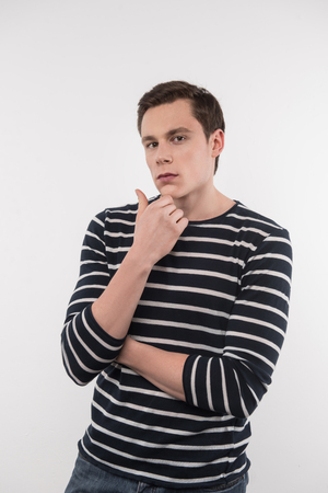 Thoughtful look. Serious handsome man touching his chin while looking at youの写真素材