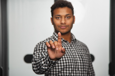 Modern servers. Skillful IT technician standing in server room and stretching handの写真素材