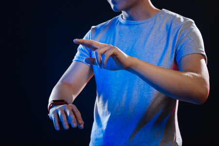 Innovative development. Pleasant young man using a new gadget while enjoying modern technologiesの写真素材