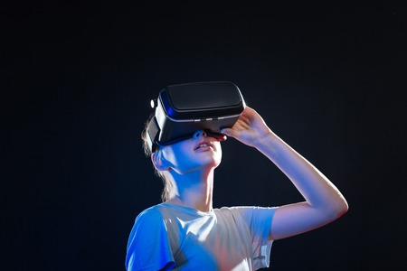 Virtual dimension. Nice young woman looking up while being in virtual reality glasses